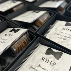 Getting the groomsmen ready to celebrate. Our 'Suit Up' invitation boxes are a stylish way to ask them to be part of the big day, featuring a sleek design and curated essentials for the main men.