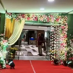A welcoming floral entrance for a wedding reception. A lush arch of pink and white flowers combined with elegant draping creates a grand entry point for guests.