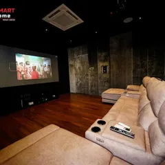A view from the corner of the sofa, showing the large screen and the in-wall speakers. This setup is perfect for a family to gather and watch movies together.