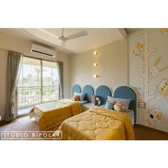 For this shared kids' room, we used a unisex palette of blue and yellow to create an energetic yet balanced space. The arched blue headboards and whimsical wallpaper create a fun and inviting atmosphere.