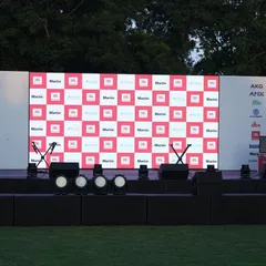 This is a frontal view of the stage setup for the Harman professional demo event. It shows the clean and organized placement of stage monitors for the performers, microphone stands, and the main front-of-house speaker stacks, all positioned for maximum audio impact.