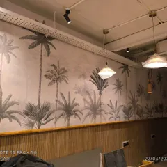 The completed look of the cafe wall, with lighting and furniture in place. The wallpaper and paneling work together to create a finished, professional interior.