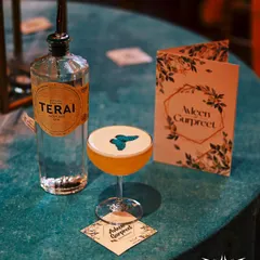 A perfect example of a personalized cocktail. This drink features a custom edible butterfly topper, served on a coaster with the couple's names, next to their personal bar menu.