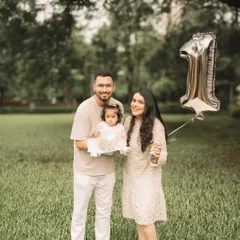 The whole family together, celebrating a very special first birthday with a golden balloon.