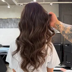 A still image of this smoky brunette look, showing the beautiful dimension and healthy shine of the hair. The soft waves are perfect for showcasing the subtle color variations.