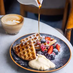 I love watching the syrup cascade over a stack of warm waffles. Mine are made to be crisp on the outside with a soft, airy heart, topped with a medley of fresh berries and a dollop of whipped cream. It’s pure, simple joy on a plate.