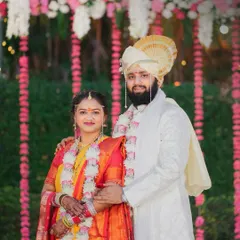 A classic portrait of a Maharashtrian couple in their wedding attire, set against a beautiful floral backdrop. We ensure every formal portrait is composed perfectly to become a cherished family heirloom.
