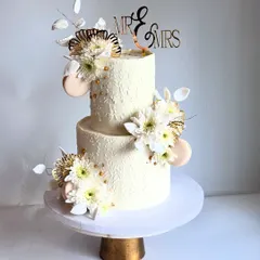 The details on this wedding cake, from the stenciled texture to the delicate placement of flowers, are what make it a true work of art.