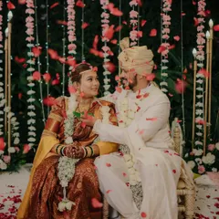 A romantic moment under a shower of rose petals. The beautiful decor and the couple's loving gaze create a truly cinematic wedding photograph.