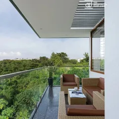 A view from the balcony of our Cube House project. We designed this space to maximize the panoramic views of the adjacent green belt, creating a serene seating area that feels far removed from the city bustle.