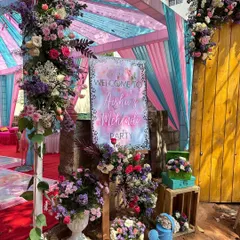 A personalized welcome sign at the entrance, surrounded by lush floral arrangements, set the perfect tone for this colorful Mehendi party.