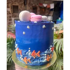 A custom cake inspired by the sea, with hand-painted waves, little fish, and macarons on top. This was for a little one who loves the ocean.