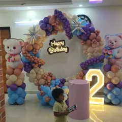 A cozy and cute Teddy Bear theme, perfect for a second birthday. This setup features a custom circular balloon arch in soft, gentle colors, paired with a large light-up number and adorable teddy bear props.