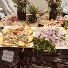 My classic Russian salad served on a bed of carved pineapple, alongside a platter of fresh sliced onions and cucumbers.