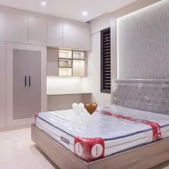 Another angle of the guest room, highlighting the tufted headboard and the custom wardrobe unit. The design ensures guests have ample storage and a comfortable space, making them feel right at home.