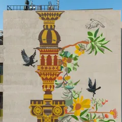 The upper portion of the hospital facade mural, where the architectural 'stambh' reaches towards the sky. The artwork is a heartfelt offering to the city, rooted in the past yet reaching for a harmonious future.