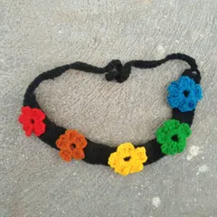 A vibrant rainbow flower headband. This piece features six colorful flowers on a black band, creating a beautiful contrast. It’s a cheerful accessory for any occasion.