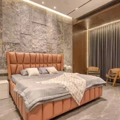 A bedroom featuring a textured stone accent wall and a hidden door seamlessly integrated into a fluted wood panel. This demonstrates our skill in creating cohesive and surprising design elements.