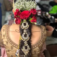 A full view of the traditional bridal braid, adorned with fresh flowers and heavy jewellery. This style is perfect for a South Indian wedding.