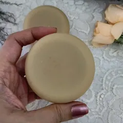 Holding a bar of my round Mild Soap. It's made with nourishing coconut milk to provide a gentle, comforting cleanse without any irritation.