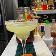 A classic Margarita with a perfectly salted rim and a lime and cherry garnish. We use fresh lime juice and premium tequila to create authentic and refreshing cocktails for your guests.