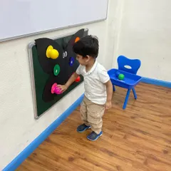 This student is confidently placing a colored piece onto the butterfly. Hands-on learning tools like this empower children to learn independently and at their own pace.