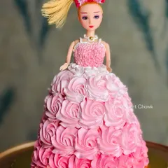 A classic doll cake design where the cake itself becomes a beautiful, flowing gown. This one features an ombre pink rosette design made with buttercream.