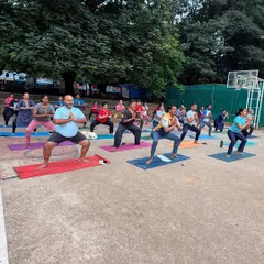 Participants in Goddess Pose during an outdoor community class. This powerful stance builds strength in the legs and cultivates a feeling of empowerment.