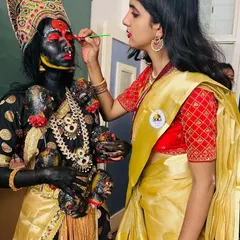 The process of creating the iconic Kali look involves careful layering of black body paint and vibrant red accents. This is where the character truly begins to take shape.