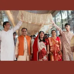 The bride's entry during a Bengali wedding, sheltered by a 'palki' held by her family. Her joyful smile as she is escorted to the mandap is a beautiful, heartwarming moment of family love and support.