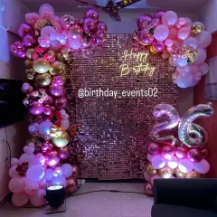 Make your celebration shine with our rose gold sequin wall. This setup is perfect for creating a glamorous atmosphere, complemented by a lush balloon arch in shades of pink and gold, a neon sign, and foil age balloons.