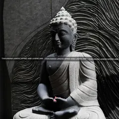 A close-up of the serene, stone-carved Buddha statue, showcasing the intricate details of the sculpture against a textured, wave-patterned background wall.