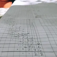 A close-up of the meticulous calculations involved in a massive long division problem. The child is not just finding an answer; she is exploring the process, checking her work, and experiencing the deep satisfaction of sustained focus.