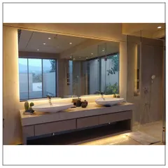 Functionality for two is key in this master bathroom design. It features dual vessel sinks on a floating vanity and a large, backlit mirror that provides ample, even lighting, all while overlooking a beautiful view.