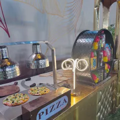A close-up of our live pizza station, where fresh pizzas are assembled and baked for guests. The station is equipped with heat lamps to keep the pizzas hot and ready to serve.