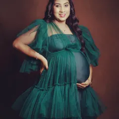 Feel like royalty in this emerald green layered tulle gown. The design includes a fitted inner dress that showcases your baby bump, with layers of soft tulle that add volume and elegance.
