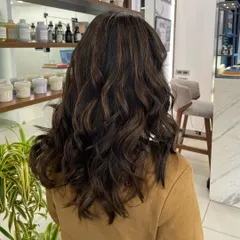 This brownie hair color has subtle, warm highlights woven through it. The result is a natural look that is full of dimension.