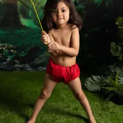 Ready for adventure with a palm leaf in hand. The jungle-themed backdrop and props in my studio create an immersive world for your little explorer.