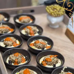 Our gourmet falafel bites, served on a bed of creamy hummus with a drizzle of spicy red sauce and a sprinkle of sesame seeds.