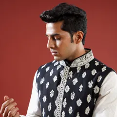 A classic black Jawahar jacket is elevated with contrasting white floral embroidery. This timeless piece is versatile enough for any festive occasion, offering a look of effortless elegance.