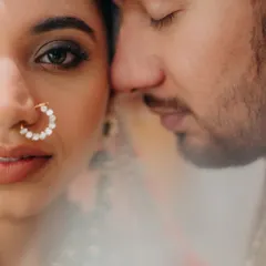 An intimate close-up, where the world blurs away and only their connection remains. This portrait focuses on the bride's expressive eyes and the gentle closeness of her partner, a quiet moment of trust and love.