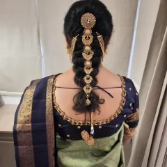 This traditional South Indian bridal braid is one of my specialties. I meticulously wove the hair and adorned it with classic golden jada accessories to create a timeless and regal hairstyle for the mother of the groom.