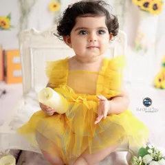 A classic, sweet portrait of a baby girl in a yellow tulle dress, part of our sunflower-themed first birthday session.