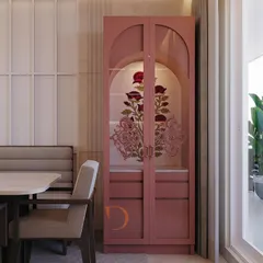 A unique and artistic pooja unit finished in a soft pink PU. The arched glass doors feature intricate floral artwork, creating a stunning focal point that is both modern and devotional.