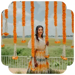 The vibrant colors of the chevron lehenga stand out beautifully against the festive marigold decor, capturing the joyful spirit of an Indian wedding.