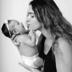 A beautiful black and white image capturing the first sweet interactions between a mother and her newborn baby.