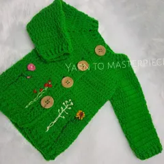 A closer look at the details on my embroidered green sweater, featuring wooden buttons and a variety of stitched wildflowers to create a unique, garden-like feel.