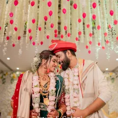 A romantic portrait of a Maharashtrian couple under a beautiful ceiling of hanging flowers after their wedding ceremony.