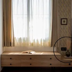 In this serene bedroom, the smart panel is placed discreetly beside the media unit. The automated sheer curtains soften the natural light, contributing to the room's calm and relaxing ambiance.
