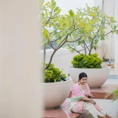 A solo shot of the bride admiring her Mehendi. The soft, natural light and the peaceful setting create a beautiful and serene portrait.